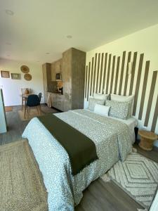 a bedroom with a large bed and a table at Refúgio do Lago in Frossos