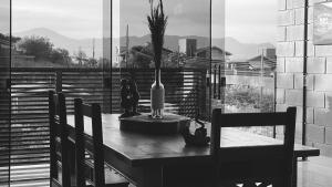 a table with a bottle and a vase on it at Rosa Paradise in Praia do Rosa