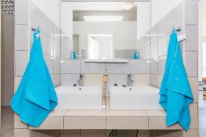 a bathroom with two sinks and two blue umbrellas at Hostel Petra Marina in Dubrovnik