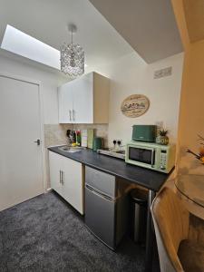 a kitchen with a counter top with a microwave at Luxury Studio Stevenage in Stevenage