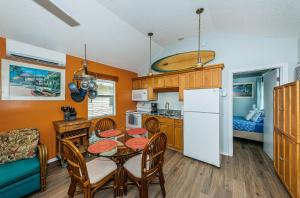 a kitchen and dining room with a table and a refrigerator at Sunset Beach Bungalow 2 in St Pete Beach +20 photos