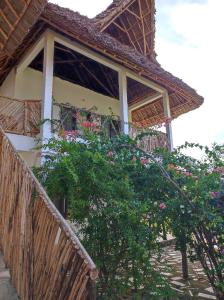 una casa con un balcón con flores. en SECRET PLACE HOTEL by HELLO TANZANIA TOURS& SAFARIS, en Makunduchi