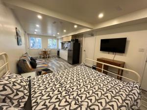 1 dormitorio con 1 cama y TV. en Modern studio with kitchenette and bath, en Guelph