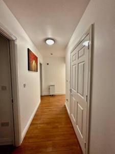 an empty hallway with a white door and wood floors at Terrace Apartment X91 RR04 in Waterford