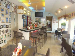 a restaurant with a bar and tables and chairs at Villa Oranje Pattaya in Pattaya Central