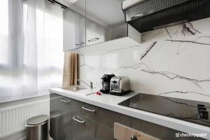 a kitchen with white marble walls and a sink at Lovely cozy appartement in Paris 15ème in Paris