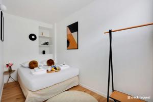 a white room with a bed with a table and a lamp at Lovely cozy appartement in Paris 15ème in Paris