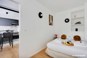 a white room with a bed and a kitchen at Lovely cozy appartement in Paris 15ème in Paris