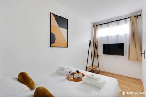 a white living room with a white couch and a tv at Lovely cozy appartement in Paris 15ème in Paris