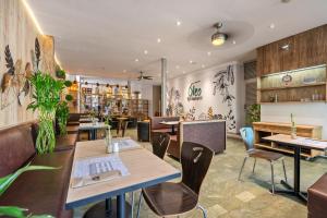 a restaurant with wooden tables and chairs and plants at Novelty Suites Hotel - Oviedo Mall in Medellín