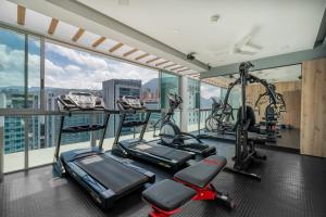 uma academia de ginástica em apartamento com esteiras e aparelhos elípticos em Novelty Suites Hotel em Medellín