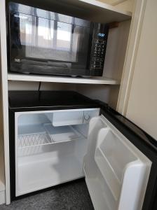 uma cozinha com um micro-ondas e um frigorífico em Osney Willow Studio Flat - Self Contained Studio Flat em Oxford