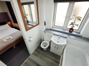 a small bathroom with a toilet and a sink at Osney Willow Studio Flat - Self Contained Studio Flat in Oxford