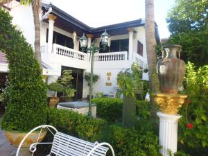 a white bench in front of a house at Villa Oranje Pattaya in Pattaya