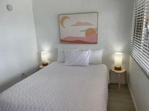 1 dormitorio con 1 cama blanca y 2 lámparas en 1 Queen Bed en Lake City