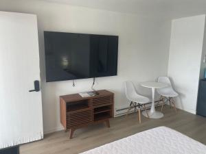 een kamer met een tv en een tafel en stoelen bij 1 Queen Bed in Lake City