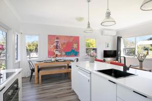 a kitchen with white countertops and a dining room at The Alfred, Mittagong in Mittagong