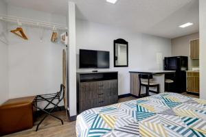 a bedroom with a bed and a kitchen with a table at Studio 6-Arlington, TX - South - Dallas in Arlington