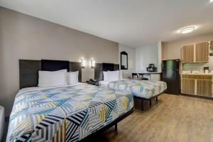 a hotel room with two beds and a kitchen at Studio 6-Arlington, TX - South - Dallas in Arlington