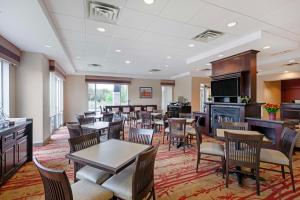 a restaurant with tables and chairs and a fireplace at Best Western Plus Muskoka Inn in Huntsville