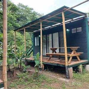 Casa pequeña azul con porche de madera y mesa de picnic en Estudios a 100mts de la Playa, en Manzanillo