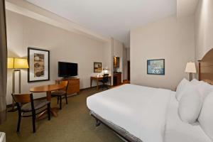 a hotel room with a bed and a desk and a television at Best Western Plus Orangeville Inn & Suites in Orangeville