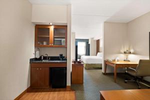 a hotel room with a kitchen and a bedroom at Best Western Plus Orangeville Inn & Suites in Orangeville
