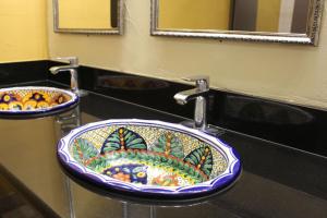 un lavabo con diseño de pescado. en Hotel Americana, en Nogales