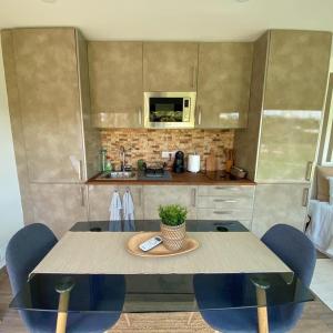 eine Küche mit einem Tisch, Stühlen und einer Mikrowelle in der Unterkunft Refúgio do Lago in Frossos