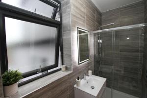 a bathroom with a sink and a glass shower at Luxury Studio Flat In London in London