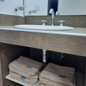 a bathroom with a sink and towels under a counter at Lacus. Casas de lago. in Almafuerte +52 photos