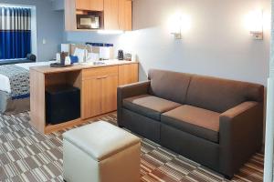 a living room with a couch and a kitchen at Starkville Inn & Suites in Starkville