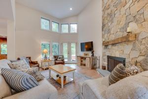 a living room with a large stone fireplace at Ski-in Condo with Hot Tub on Burke Mtn Slopes! in East Burke