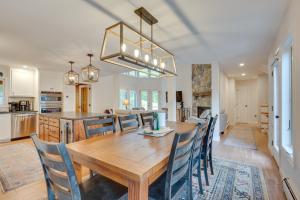 a kitchen and dining room with a wooden table and chairs at Ski-in Condo with Hot Tub on Burke Mtn Slopes! in East Burke