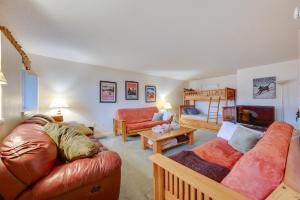 a living room with a couch and a table at Ski-in Condo with Hot Tub on Burke Mtn Slopes! in East Burke