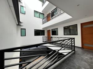 un escalier dans un bâtiment avec des balustrades noires dans l'établissement Departamento en CDMX, zona norte, à Mexico