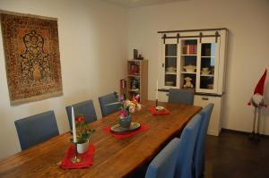Niederburger Herberge في Niederburg: غرفة طعام مع طاولة خشبية وكراسي زرقاء