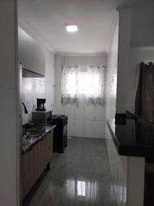 a kitchen with white walls and a window at Apartamento belvedere do lago in Serra Negra