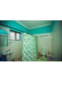 a bathroom with a toilet and a shower curtain at Matata Homes Airbnb in Kasoa