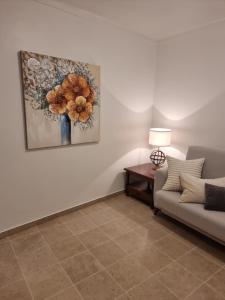 a living room with a couch and a painting on the wall at Casa Jasmim in Faro