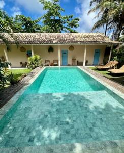 a swimming pool in front of a house at Pousada Caraíva in Caraíva