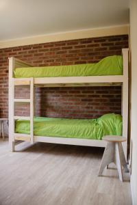 Ce lit se trouve dans un dortoir doté de 2 lits superposés et d'un mur en briques. dans l'établissement La Casita Boutique, à Chos Malal