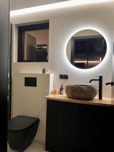uma casa de banho com um lavatório e um espelho em Glass roof lodge with private hot tub em Reykholt