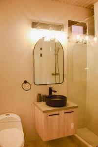 a bathroom with a sink and a toilet and a mirror at Amazing location Spacious Apto with Rooftop in Panama City