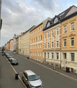 uma rua com carros estacionados ao lado de um edifício em 130m² Designerwohnung mit 2 Vollbädern em Gera