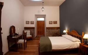 a bedroom with a bed and a table and a desk at Hacienda La Cienega in Latacunga