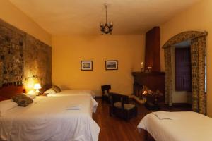 a hotel room with two beds and a fireplace at Hacienda La Cienega in Latacunga