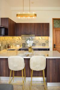 een keuken met een groot eiland met twee stoelen bij Modern luxury Studio with Rooftop + parking in Panama-Stad