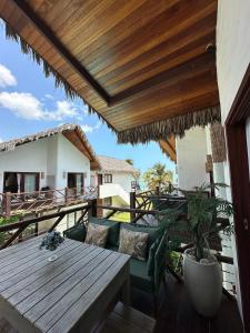 patio con mesa de madera y sillas en el balcón en Reserva BG - Praiano - Vista mar, en Barra Grande