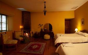 a bedroom with two beds and a mirror and a fireplace at Hacienda La Cienega in Latacunga